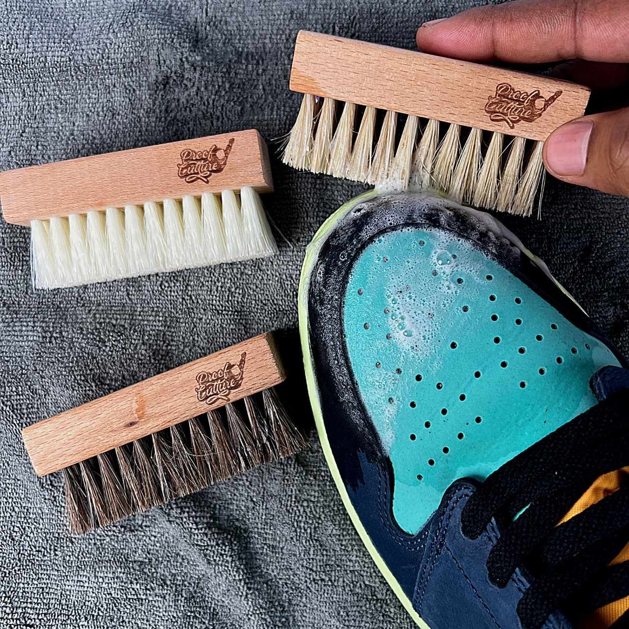 Proof Culture premium shoe cleaning brush kit in use on turquoise toe box