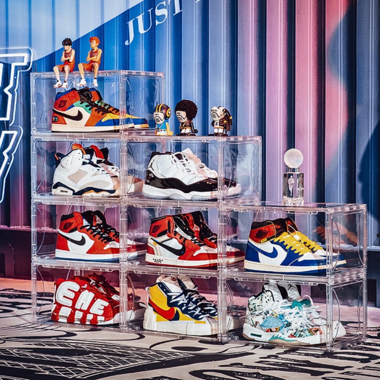 Stack of collectible sneakers displayed in clear Proof Culture shoe storage boxes with colorful backdrop