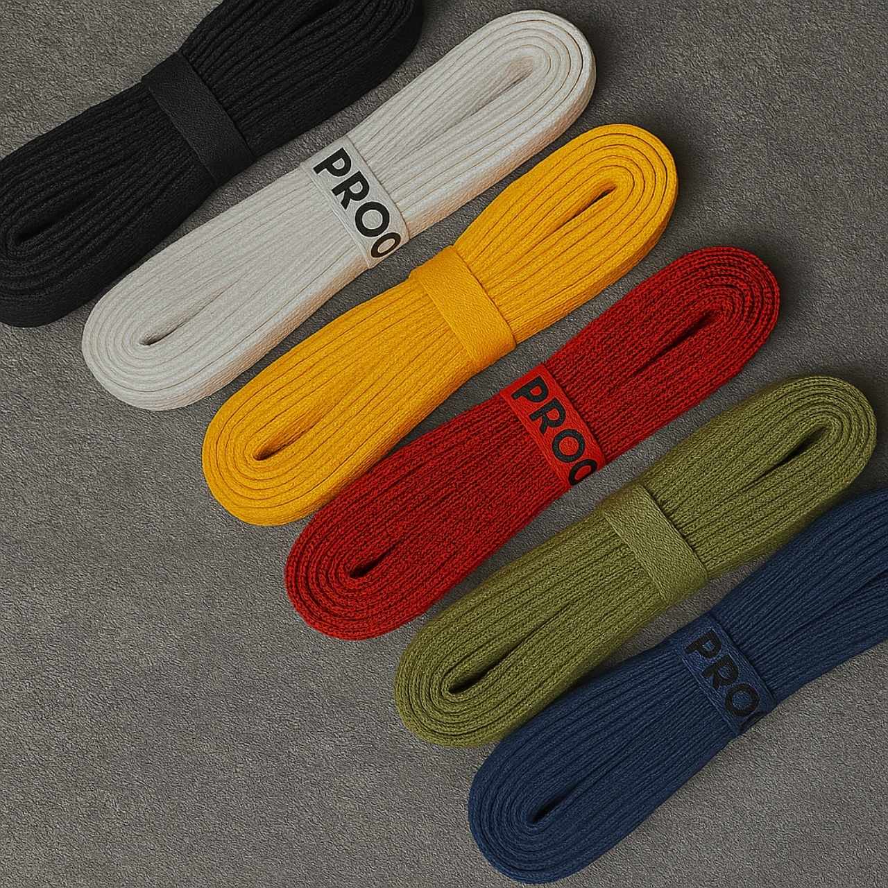 Six colorful flat shoelace bundles from Proof Culture arranged on textured background, showcasing black, white, yellow, red, green, and blue styles.